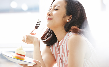 ケーキをほおばる女性